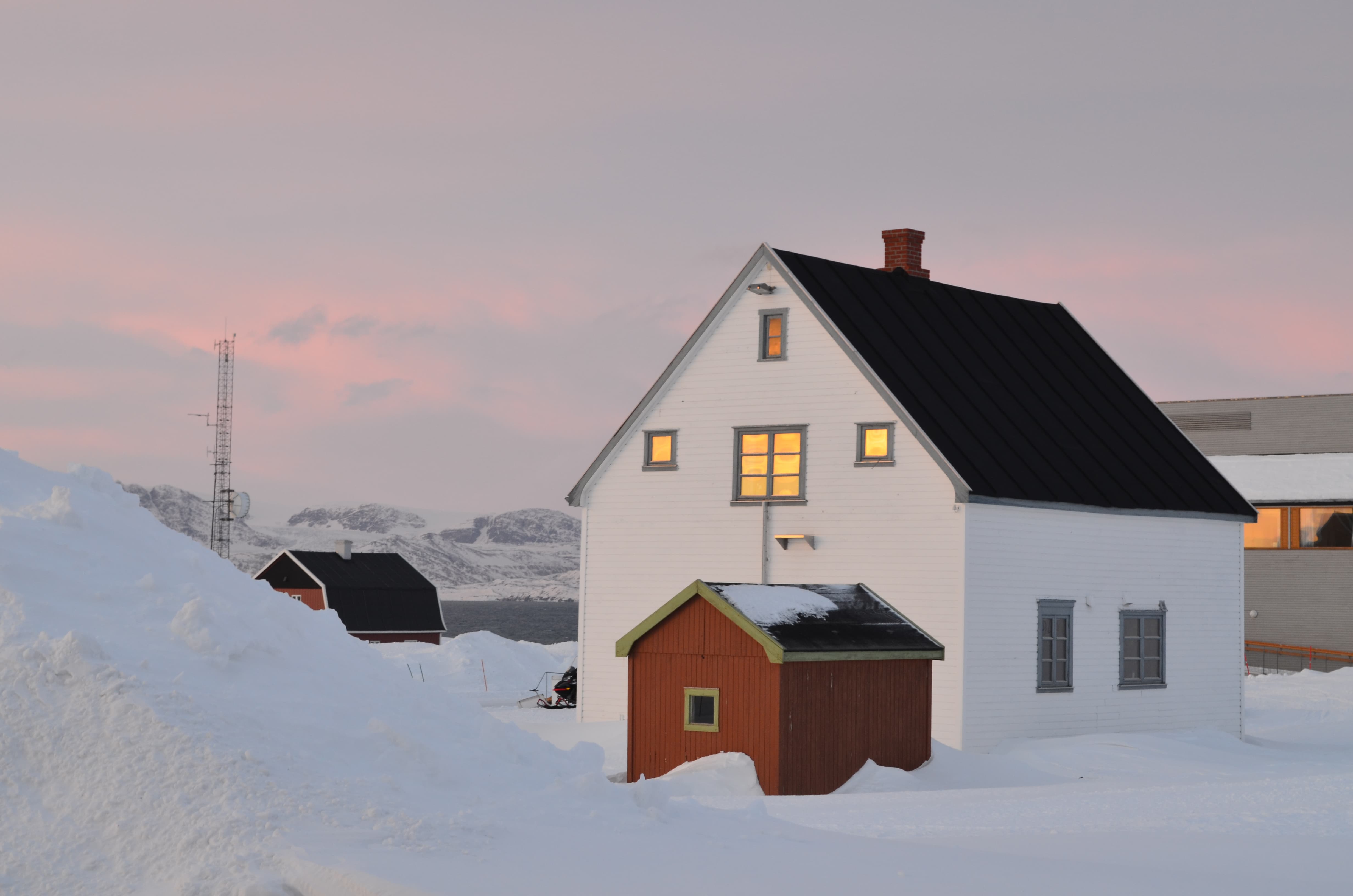 A house in the middle of a snowy landscape in Ny-Ålesund, in Northern Spitsbergen.